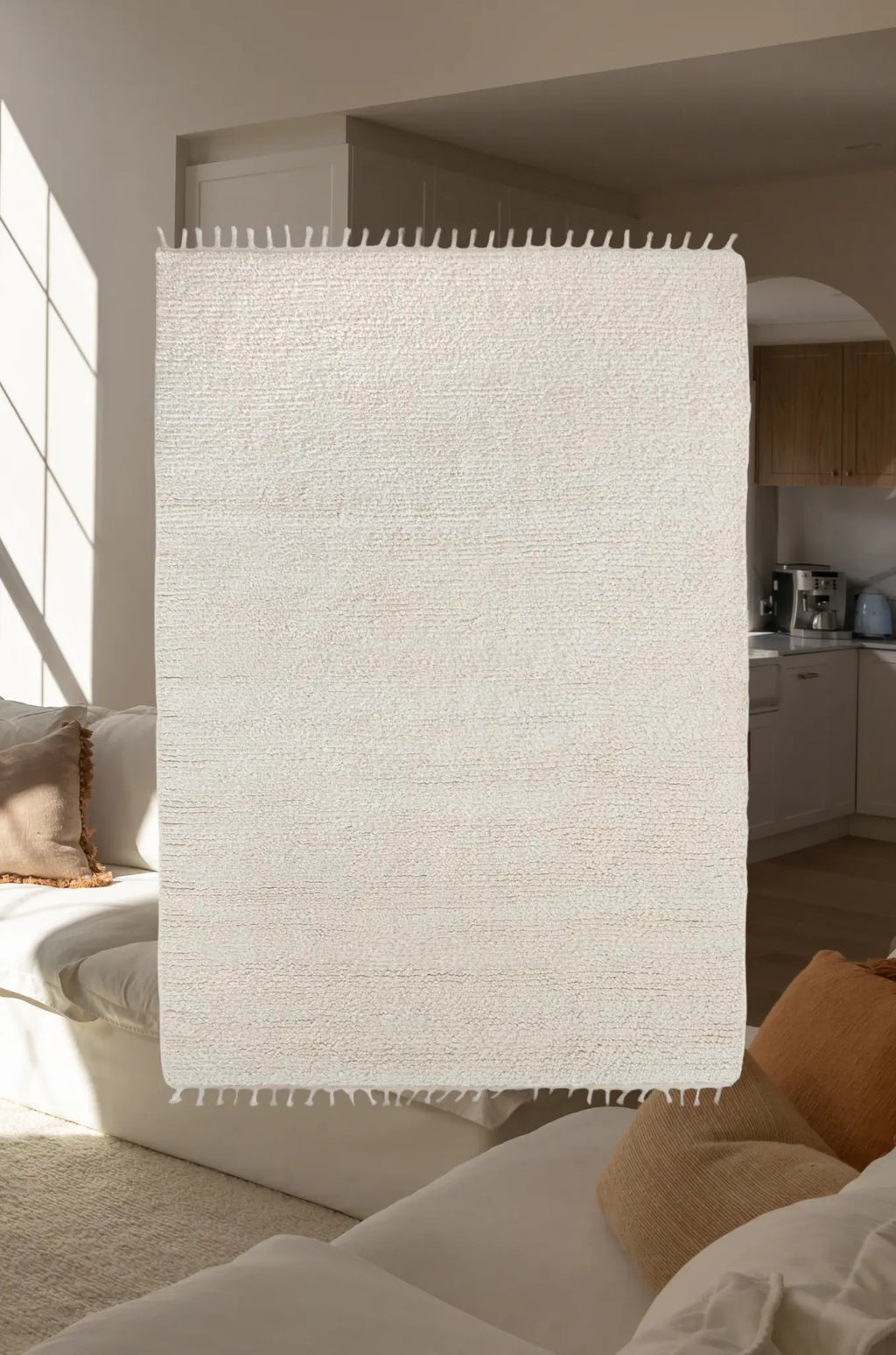 Ivory textured rug in a living room setting with furniture and decor.