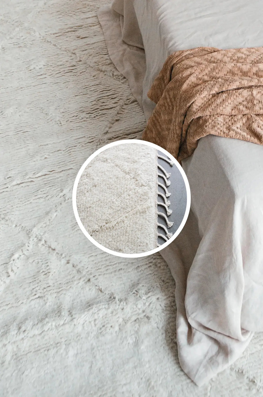 Close-up of a Prana in ivory rug with a pillow and blanket on top